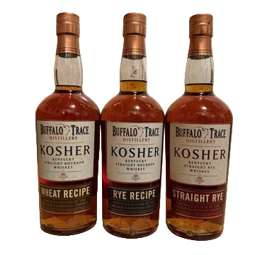 Three bottles of Buffalo Trace Kosher whiskey on a wooden surface with a wooden panel background.